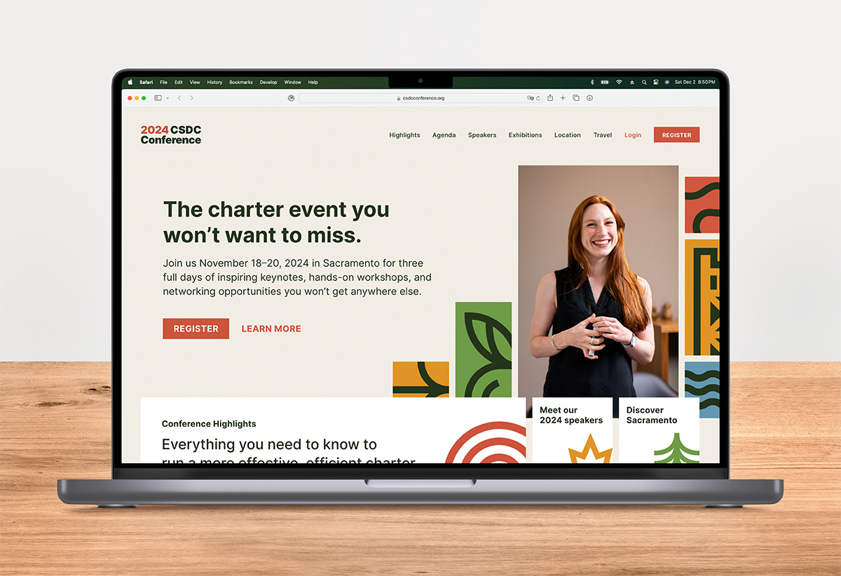 The CSDC website displayed in a Macbook sitting on a wooden desktop with a gray wall behind