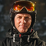 A photo of David, one of the personas for Powder. David is a male who looks to be in his sixties or early seventies, and he has a black helmet and orange ski goggles on his head.